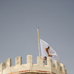 Член Иерусалимского отделения ИППО А.В.Тимофеев поднимает флаг на южную башню Сергиевского подворья в Иерусалиме