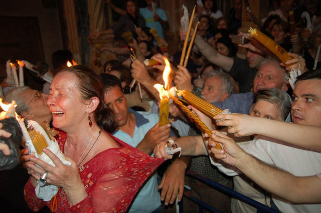 Верующие передают друг другу Благодатный Огонь. Фото © паломнический центр "Россия в красках" в Иерусалиме