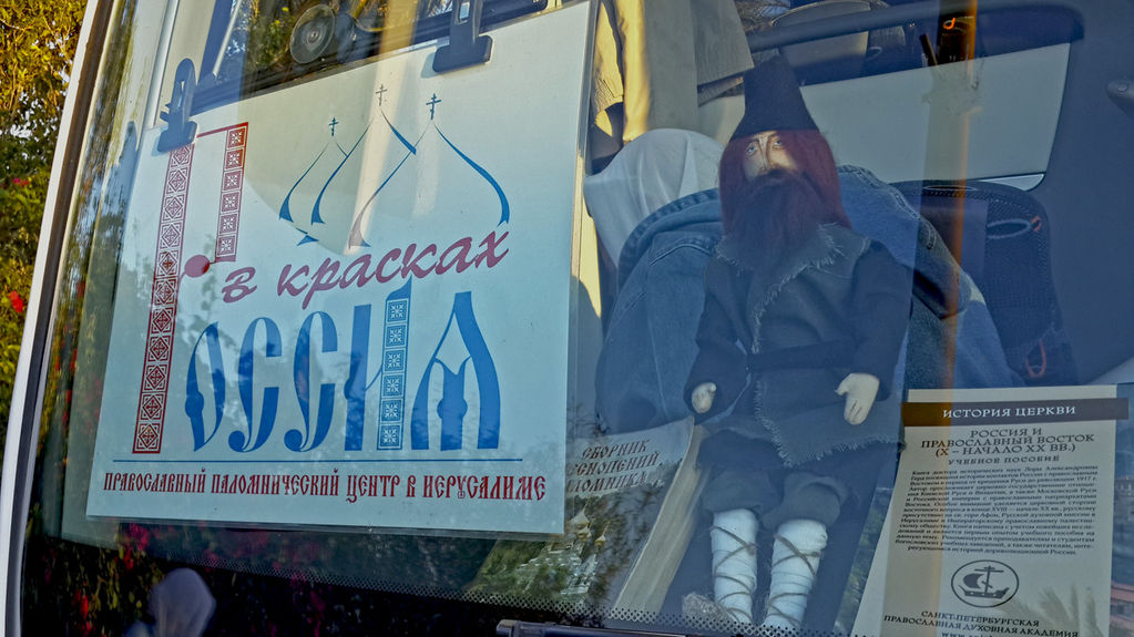 Кукла "Паломник Серафим" за лобовым стеклом атобуса - авторская работа паломницы Юлии из Санкт-Петербурга