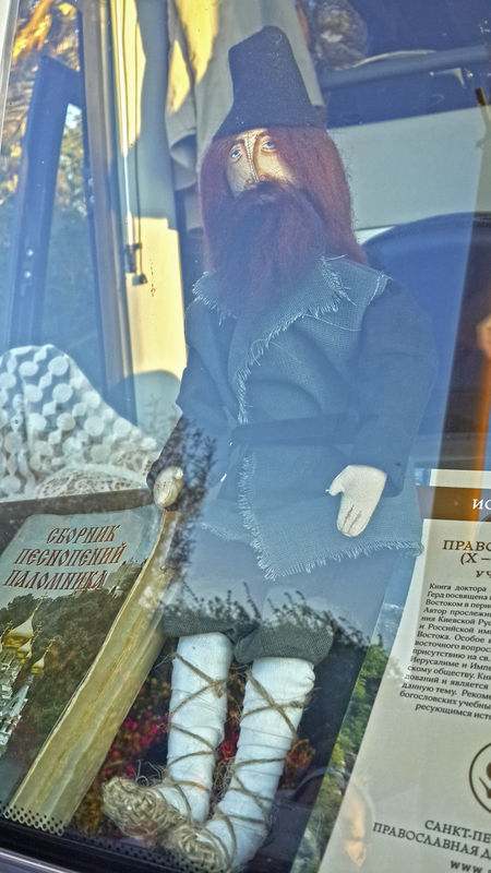 Кукла "Паломник Серафим" за лобовым стеклом атобуса - авторская работа паломницы Юлии из Санкт-Петербург