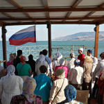 Торжественное поднятие флага России под гимн России на лодке в море Галилейском