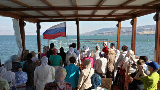 Торжественное поднятие флага России под гимн России на лодке в море Галилейском
