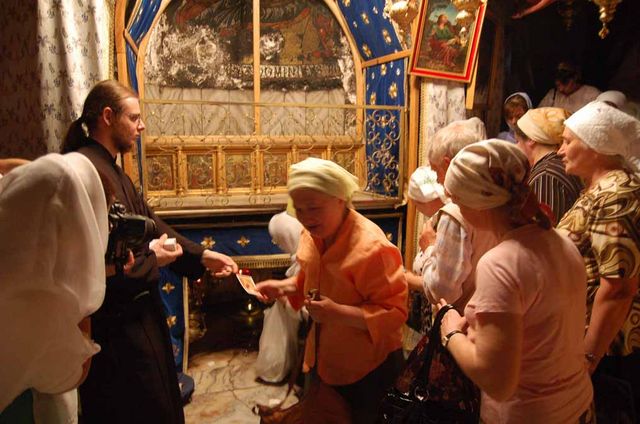 Греческий православный монах благословляет православных паломников иконками Рождества. © "Россия в красках"